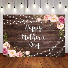 a wooden sign that says happy mother's day with pink flowers and string lights