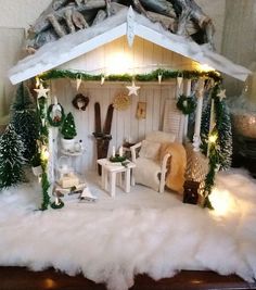 a doll house is set up with lights and decorations on the outside, including a porch