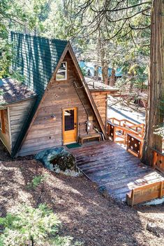 a small cabin in the woods with stairs leading up to it's door and porch