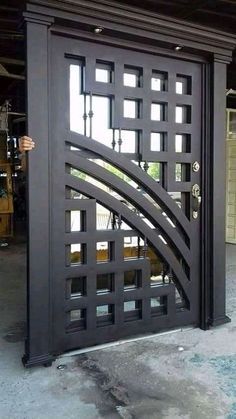 a man standing in front of a black door with an intricate design on the side