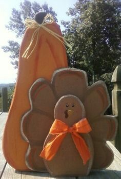 a stuffed turkey sitting on top of a wooden table next to a pumpkin shaped bag