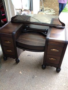 a desk with a mirror on top of it in front of a person's house