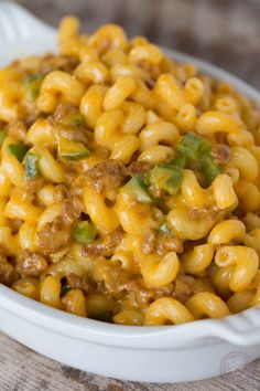 a white bowl filled with macaroni and cheese on top of a wooden table