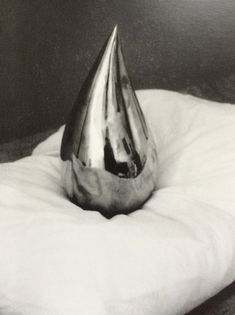 a silver vase sitting on top of a white pillow