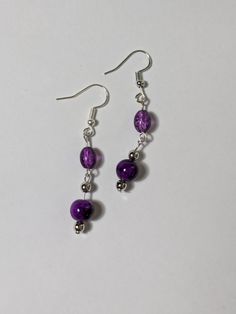 Elevate your jewelry collection with these lovely purple beaded dangling earrings. The round shape and silver tone metal create a chic and sophisticated look, while the hook closure ensures comfortable wear.  Only the best materials are used to create each piece of jewelry  - Glass beads  - Acrylic beads  - Silver tone components Hypoallergenic Purple Beaded Earrings, Purple Metal Drop Earrings, Purple Drop Crystal Earrings, Purple Metal Beaded Drop Earrings, Purple Metal Dangle Earrings, Nickel-free Purple Beaded Earrings With Round Beads, Purple Dangle Metal Earrings, Nickel-free Purple Beaded Earrings, Purple Adjustable Drop Crystal Earrings