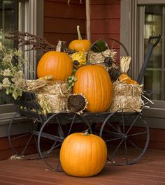 a wagon filled with pumpkins sitting on top of a wooden floor next to a window