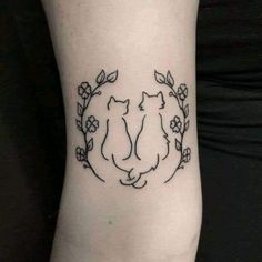 a woman's arm with two cats in a circle tattoo on the left side