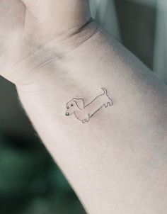 a small dachshund tattoo on the wrist