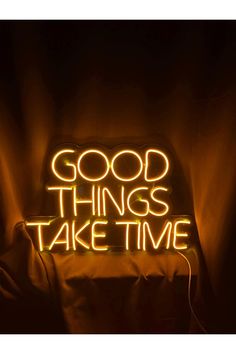 a neon sign that says good things take time in the middle of a dark room