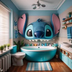 a bathroom decorated in blue and pink with an elephant head on the wall above the bathtub