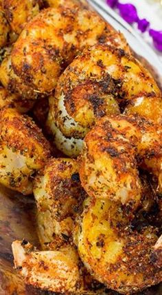 grilled shrimp on a wooden cutting board with purple flowers in the backgroud