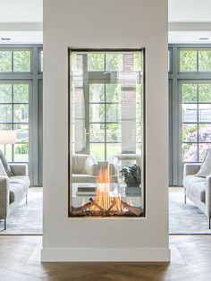 a living room with two couches and a fire place in the middle of it