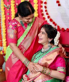 a woman in a pink and green sari getting ready to go on her wedding day