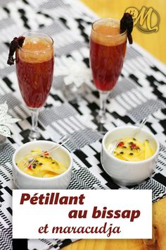 two glasses filled with liquid sitting on top of a table next to bowls of food