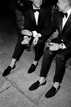 two men in tuxedos are sitting down