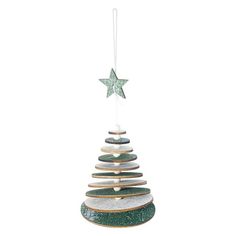 a ceramic christmas tree ornament hanging on a white wall with a star above it