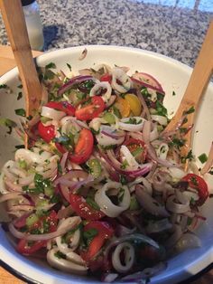 a white bowl filled with onions and tomatoes