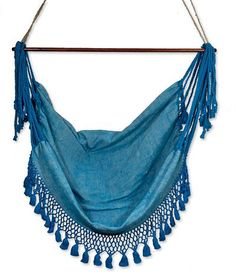 a blue hammock hanging from a rope with tassels