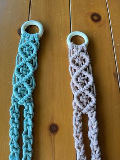 two crocheted objects sitting on top of a wooden table next to each other