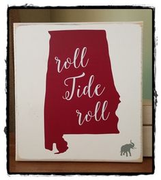 a red and white sign with the word roll tide roll on it's side