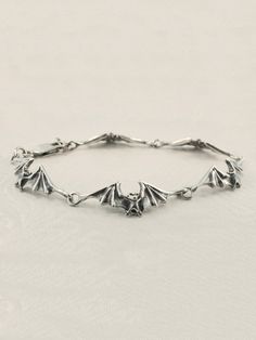 "This sculptural bat bracelet consists of 5 detailed bats linked wing tip to wing tip creating a beautiful scalloped pattern. 5 bat links is 6 1/4\" in length and 6 bat links is 7 1/4\" in length and fits most wrists. Take flight with these magical creatures! This item usually ships the same or next business day All Marty Magic Jewelry is packaged in a beautiful box, embossed with the gold foil Marty Magic dragon logo. Perfect for any occasion! Designed in Santa Cruz California by Marty Magic. M Bat Bracelet, Magic Jewelry, Dragon Logo, Magic Dragon, Bat Jewelry, Linked Bracelet, Jewelry Halloween, Santa Cruz California, Bat Wing