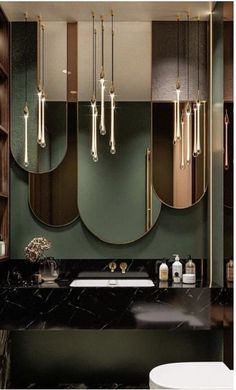 a bathroom with marble floors and green walls, along with gold mirrors on the wall