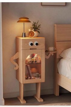 a wooden bed with a lamp on top of it next to a night stand that has an electronic device in the shape of a robot