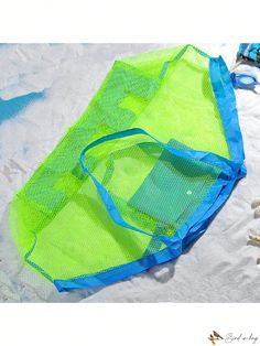 a green and blue mesh bag sitting on top of a beach next to starfish