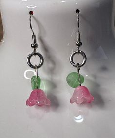 These handmade flower earrings feature Czech glass beads and glass leaf beads. Pink flower with a white seed bead and a light green leaf. They measure about an inch and a half long from the bend in the hook. Nickel-free Czech Glass Flower Earrings, Czech Glass Flower Earrings For Gifting, Green Czech Glass Flower Earrings, Czech Glass Flower Earrings For Gifts, Czech Glass Flower Earrings With Flower Charm, Green Earrings With Flower Charm For Jewelry Making, Green Flower-shaped Jewelry With Dangling Beads, Green Dangling Bead Flower Earrings, Green Dangle Flower Earrings With Beads