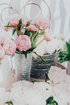 pink and white flowers are in vases on a table