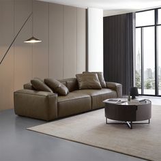 a modern living room with large windows and leather furniture