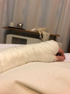 a person with a cast on their arm laying in bed