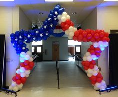 an arch decorated with red, white and blue balloons