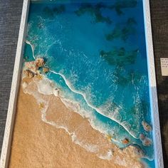 an aerial view of the ocean and beach with waves coming in from the water, taken from above