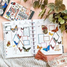 an open planner with butterflies on it next to a potted plant and other items