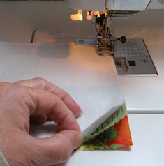 a person is using a sewing machine to sew something on a piece of fabric