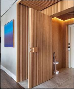 an open door in a room with wooden slats on the walls and wood flooring