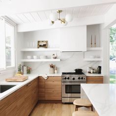 a kitchen with white counter tops and wooden cabinets, along with a stove top oven