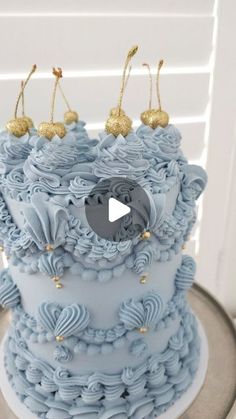 a cake with blue frosting and gold decorations on it's top is shown