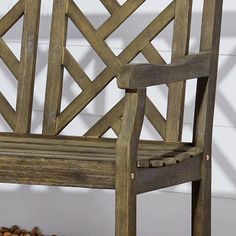 a wooden bench sitting next to a pile of rocks on the side of a building