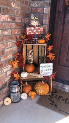 a small shelf with pumpkins and other decorations on the front door steps, next to a sign that says it's halloween