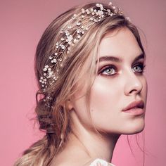 a woman wearing a headpiece with flowers on it's side and hair in the middle