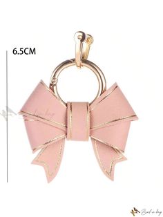 a pink bow keychain with gold trimmings on the front and back