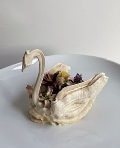 a white plate topped with a stuffed swan