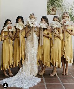 a group of women standing next to each other holding flowers in front of their faces