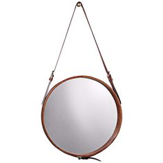 a round mirror hanging from a leather strap