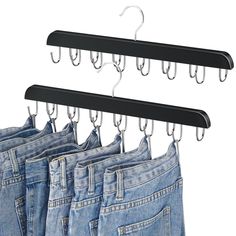 four pairs of jeans hanging on hooks in front of white background with clippings