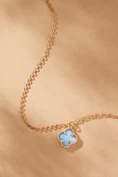 Simplicity in design but elegant in its statement, this 14K gold clover charm necklace is timeless in your jewelry box. Featuring a light blue clover charm outlined in gold and displayed on a dainty gold chain, this necklace creates an aura of beauty radiating from within and encapsulating its wearer. Elegant Blue Charm Necklace With Adjustable Chain, Elegant Blue Flower Shaped Necklace, Elegant Blue Flower-shaped Necklace, Blue Dainty Necklace With Flower Pendant, Dainty Blue Flower Pendant Necklace, Blue Dainty Flower Pendant Necklace, Elegant Blue Gold-plated Charm Necklace, Dainty Blue Clavicle Charm Necklace, Dainty Gold Chain