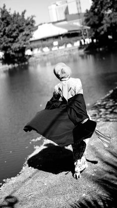 black and white photograph of a woman standing by the water