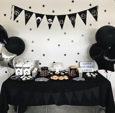 a black and white dessert table with balloons